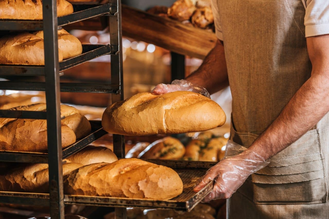 cropped shot of shop assistant arranging loafs of bread in supermarket.jpg
